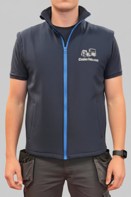 A man wearing a navy blue sleeveless quarter-zip Gilet with a bright blue zipper and a white 'Conlan Oils.com' logo on the left chest.
